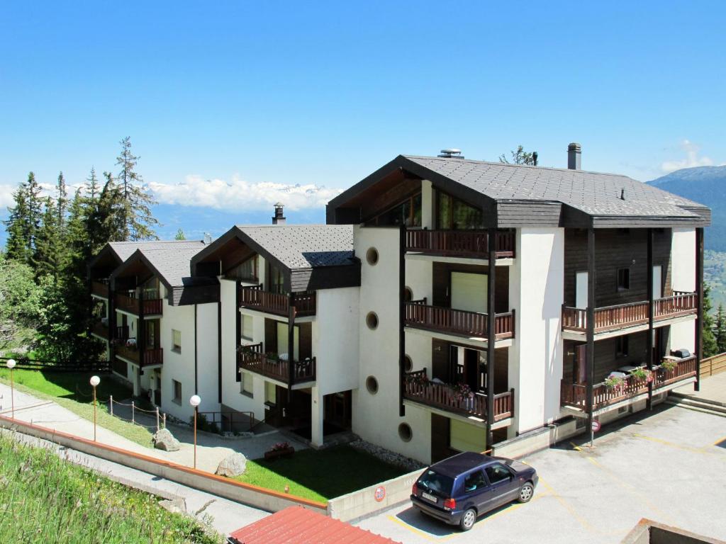 ein Gebäude mit einem Auto auf einem Parkplatz in der Unterkunft Apartment Hameau D01 by Interhome in Les Collons