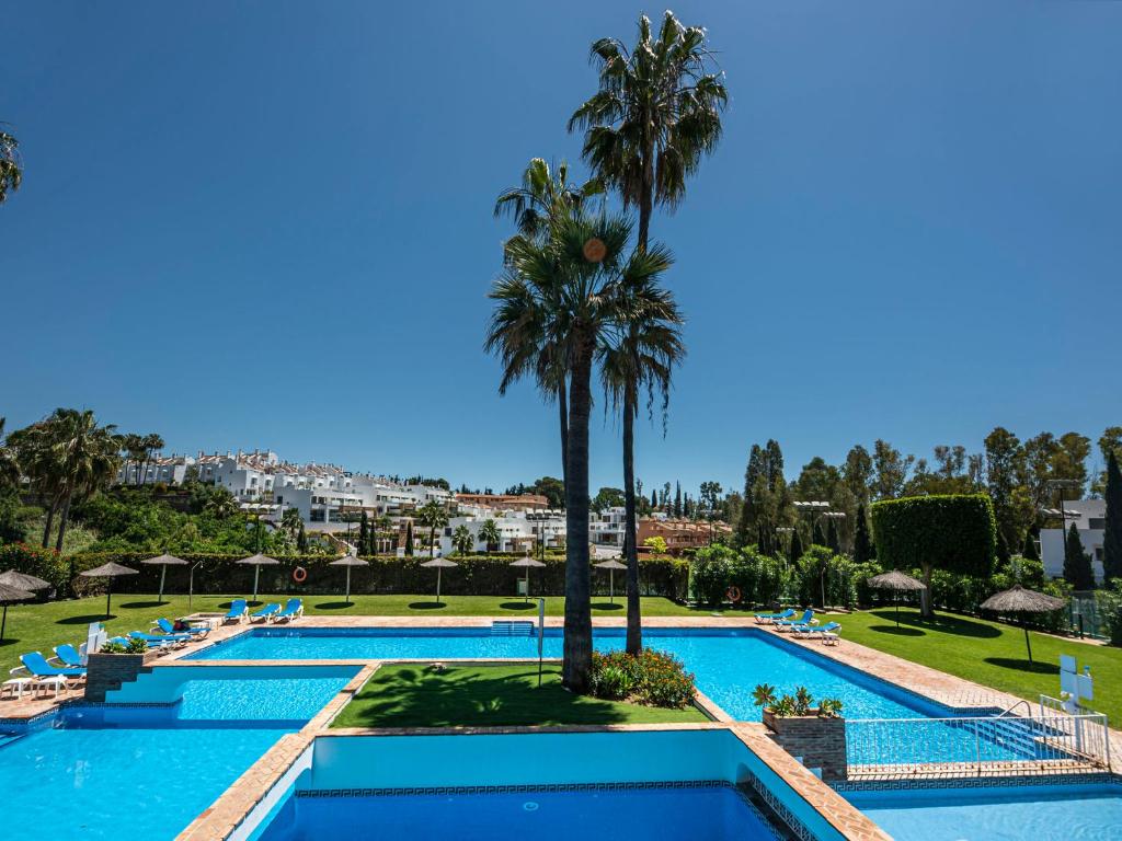 - une vue sur la piscine du complexe et ses palmiers dans l'établissement Apartment Senorio de Marbella by Interhome, à Marbella
