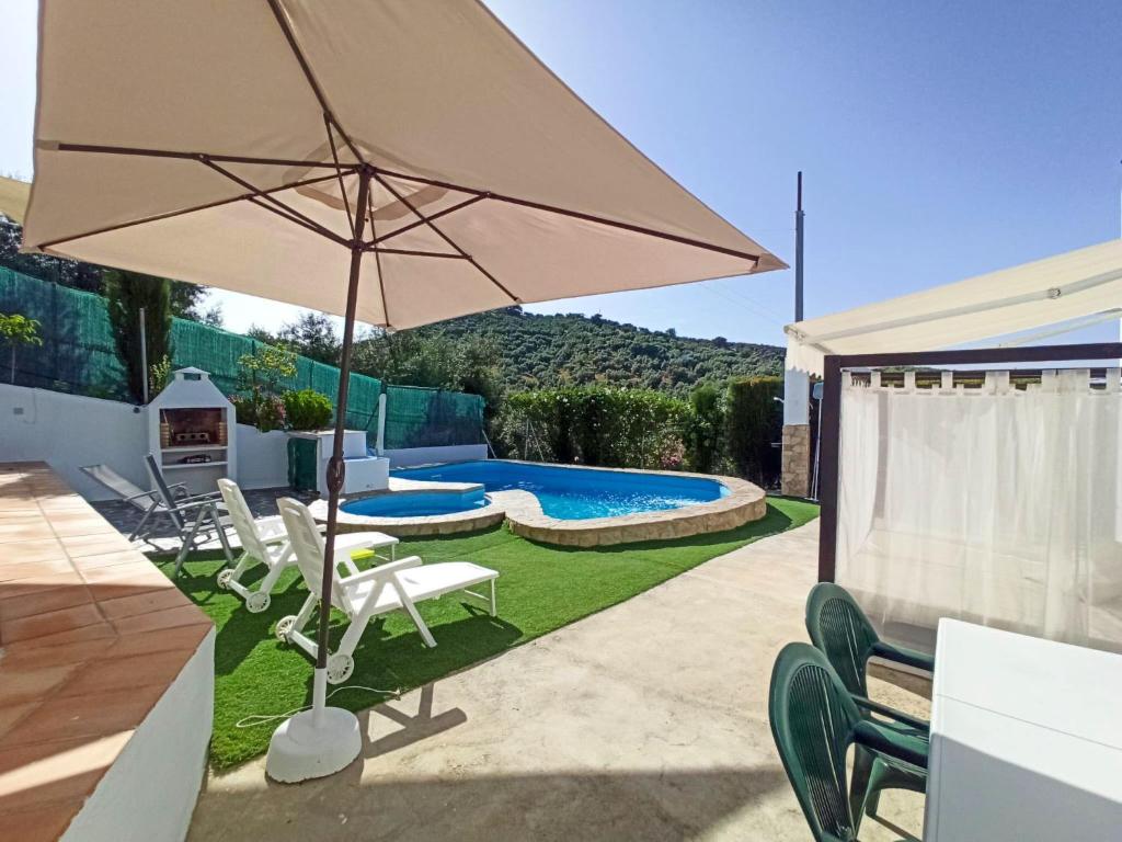 a patio with an umbrella and chairs and a pool at Holiday Home El Viso by Interhome in Zambra