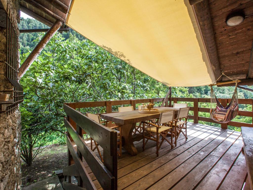 una terrazza in legno con tavolo e sedie. di Holiday Home Al Fopp by Interhome a Masino