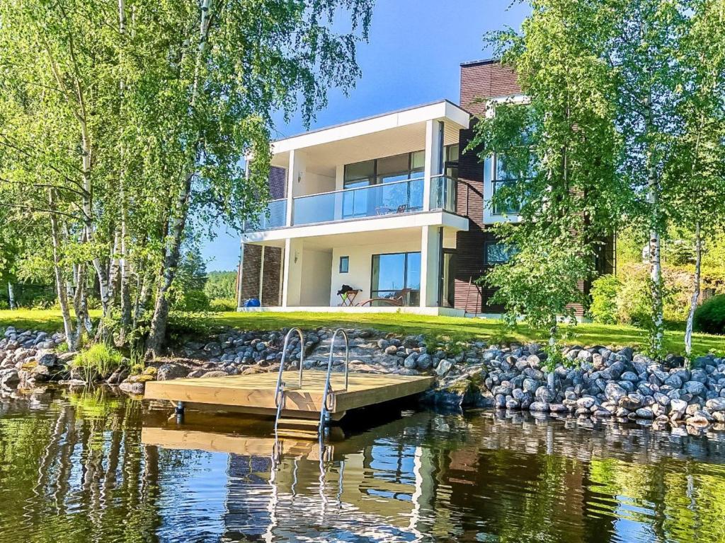 a house on the shore of a lake with a dock at Holiday Home Villa marina by Interhome in Padasjoki