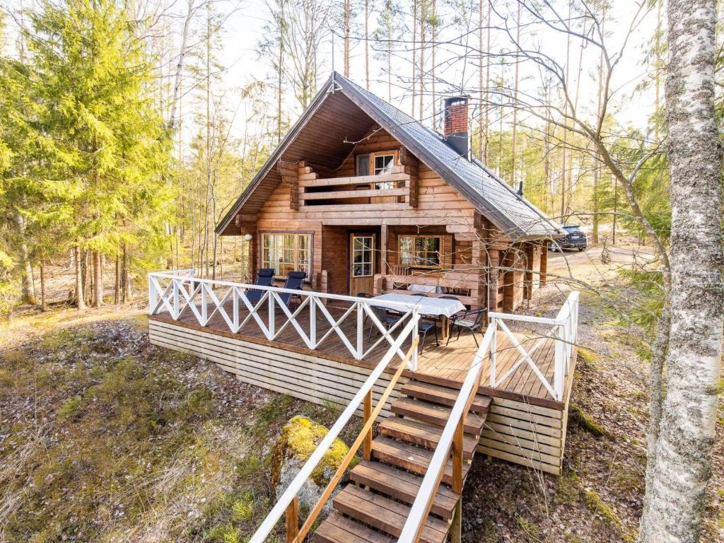 una cabaña de madera en el bosque con escaleras que conducen a ella en Holiday Home Paapuuri by Interhome, en Asikkala