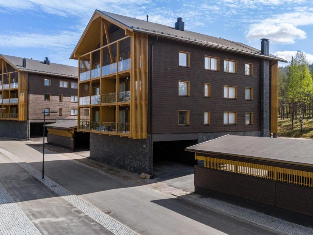 an apartment building with a wooden facade and a building at Holiday Home Tunturinlaita b3 by Interhome in Sirkka