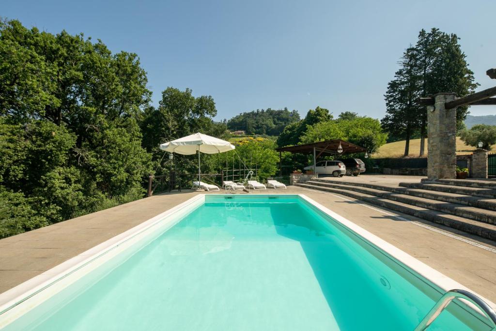 une piscine avec des chaises et un parasol dans l'établissement Villa Scarperia by Mmega, à Fondaccio