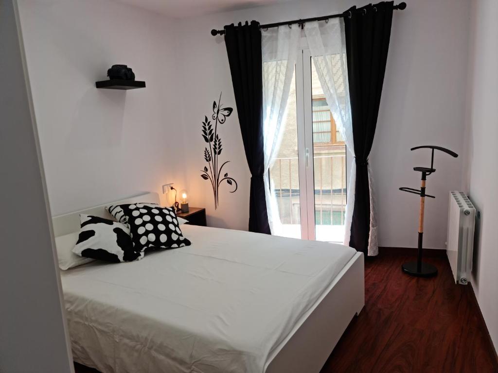 a bedroom with a bed and a window at Ca la Maria in La Seu d'Urgell