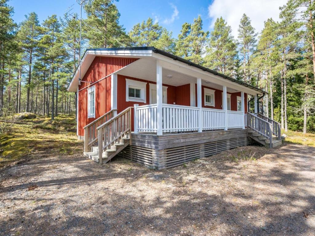 a red cottage in the woods with trees at Holiday Home Tallbacka 2 by Interhome in Bromary