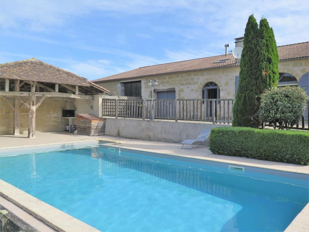 uma grande piscina azul em frente a uma casa em Holiday Home Saint Martin by Interhome em Puymiclan