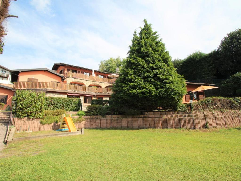 a large house with a tree in a yard at Apartment Residenza Agrifoglio-8 by Interhome in Luino
