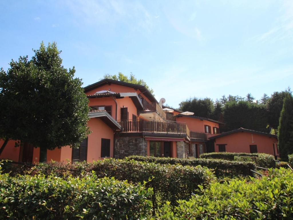 a large pink house with trees and bushes at Apartment Residenza Agrifoglio-10 by Interhome in Luino