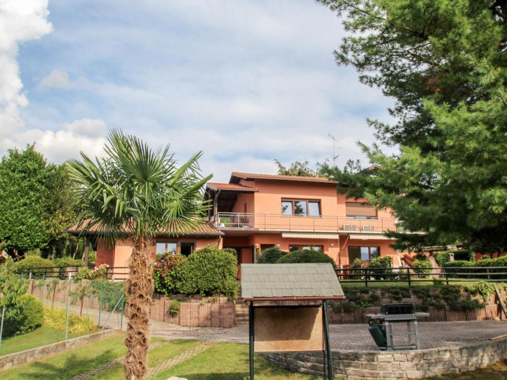 a house with a palm tree in front of it at Apartment Residenza Agrifoglio-13 by Interhome in Luino