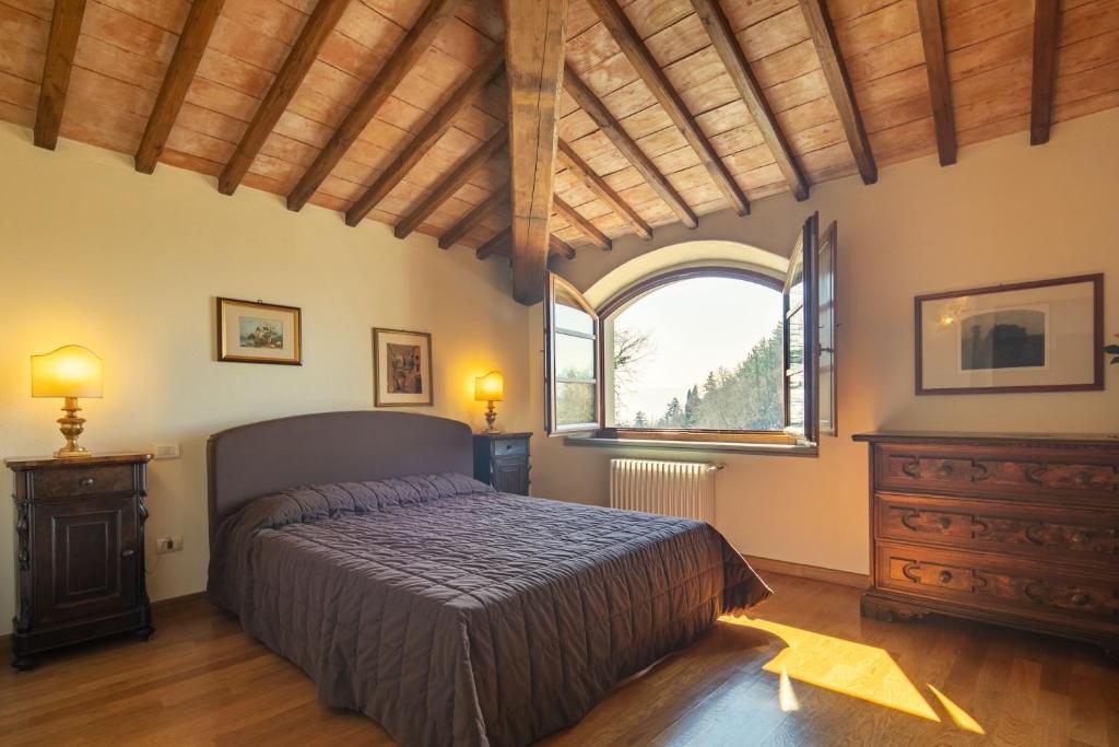 une chambre avec un lit et une grande fenêtre dans l'établissement Villa Scarperia by Mmega, à Fondaccio