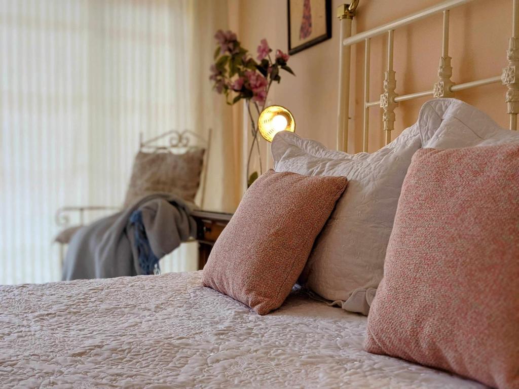 Un dormitorio con una cama con almohadas. en El Desván Candeleda, en Candeleda