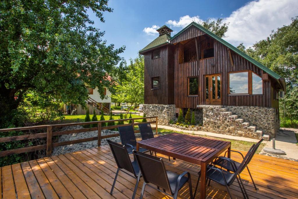 een houten terras met een tafel en stoelen voor een huis bij River house Vasa in Belgrado