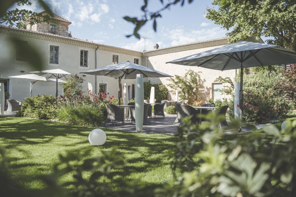 尼姆的住宿－馬斯德博登酒店，草地上带椅子和遮阳伞的院子