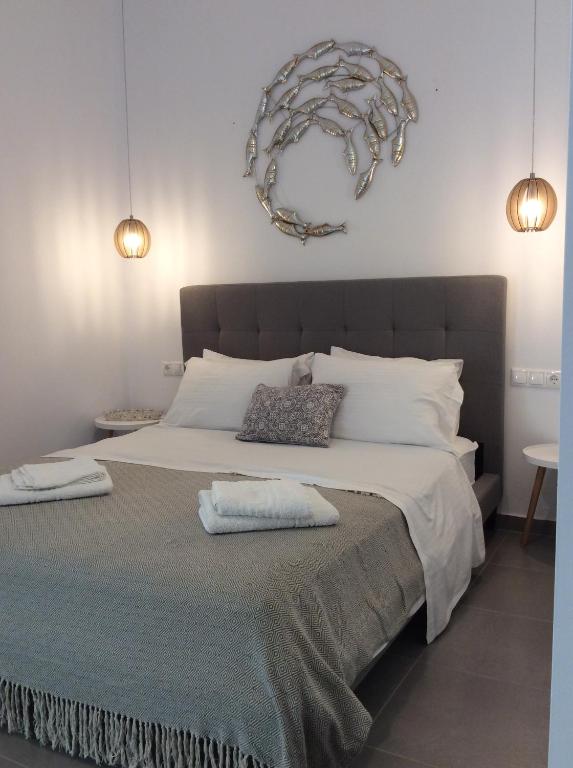 a bedroom with a large bed with two pillows on it at studios FLORA in naoussa paros in Naousa