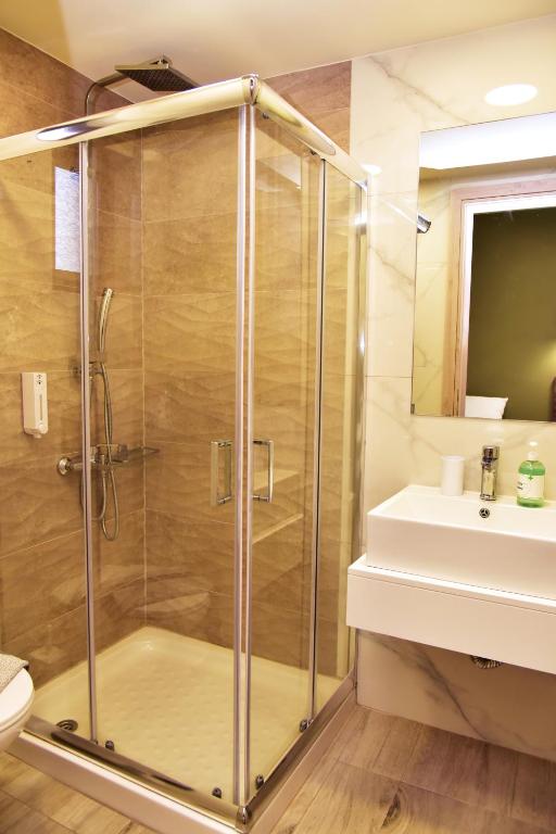 a shower with a glass door next to a sink at Lafo Rooms in Elafonisi