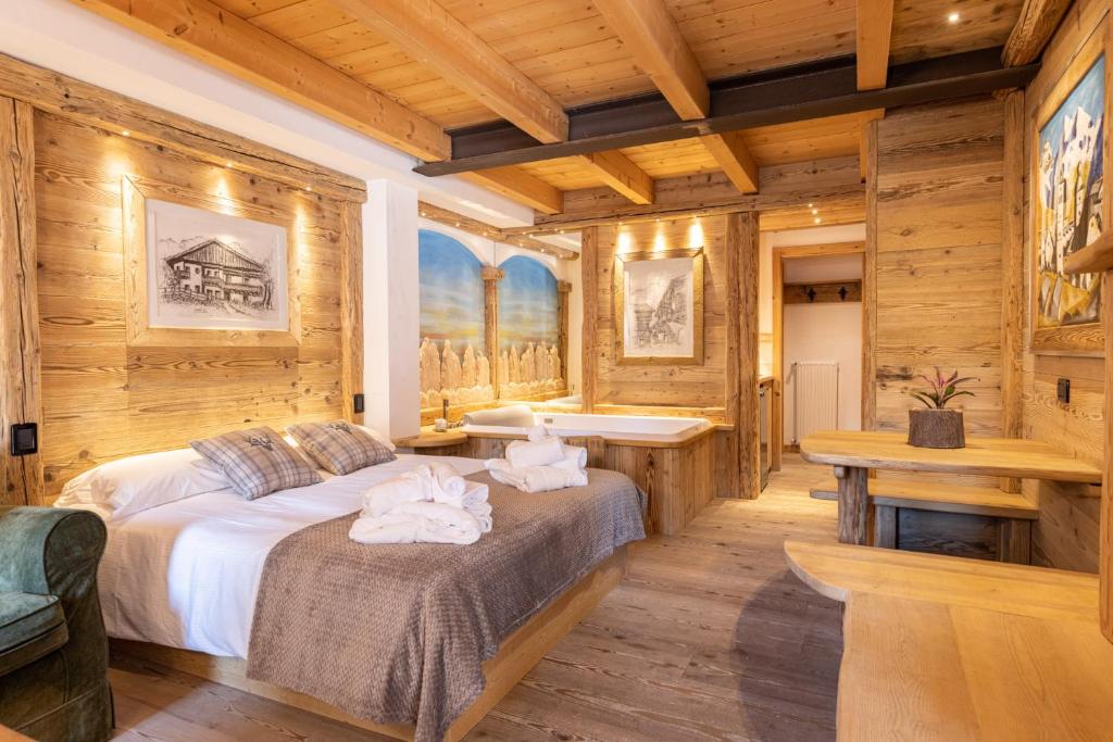 a bedroom with a bed and a bath tub at Ciandolada Wellness in Vodo Cadore
