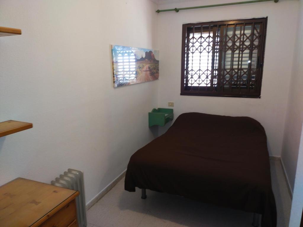 a small room with a bed and a window at guajara-loft in La Laguna