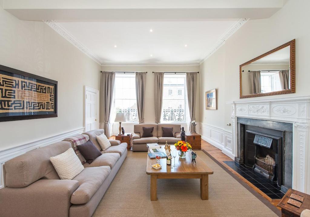 uma sala de estar com um sofá e uma lareira em The New Town Idyll @ Dublin Street em Edimburgo