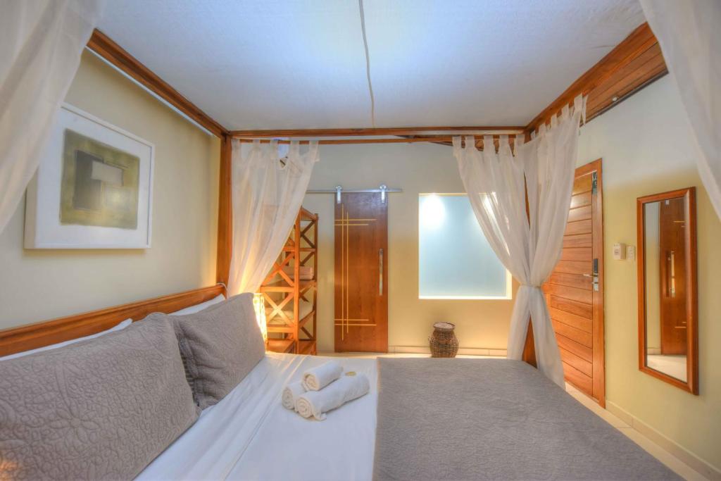 een slaapkamer met een bed met witte lakens en een raam bij Pousada Treze Luas in Ilha do Mel