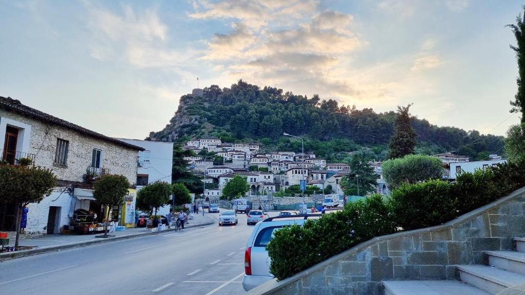 a city street with cars parked on the side of a mountain at Downtown Apartment in Berat