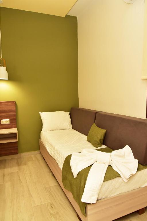 a bed in a room with a green wall at Lafo Rooms in Elafonisi