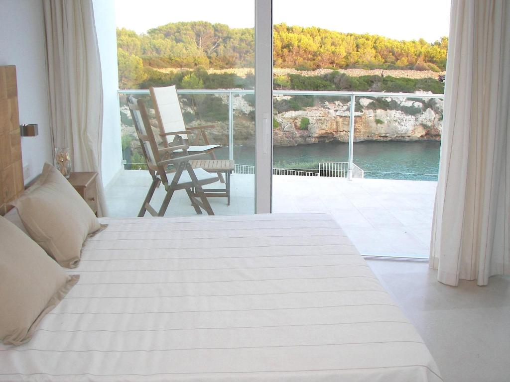 a bedroom with a bed and a view of a balcony at Villa Mar in Cala en Blanes