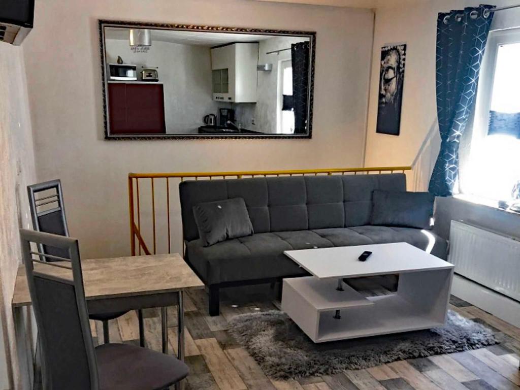 a living room with a couch and a table and a mirror at City Apartment in Waren Müritz in Waren