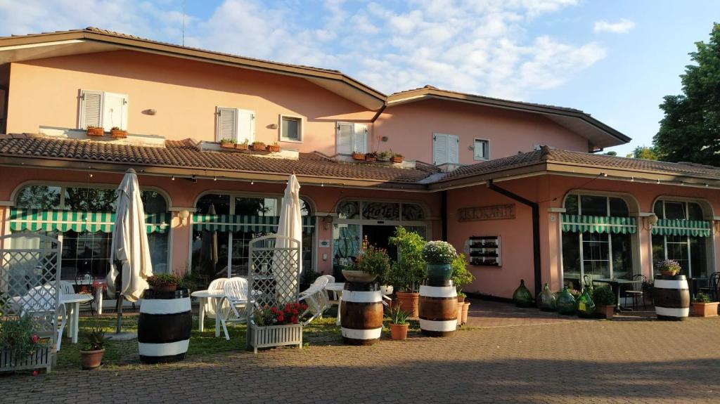 un bâtiment avec des parasols et des chaises devant lui dans l'établissement Hotel Ristorante alla Campagna, à San Giovanni Lupatoto