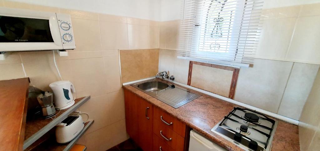 a small kitchen with a sink and a microwave at Granada Apartments Familiar Deluxe in Portinatx