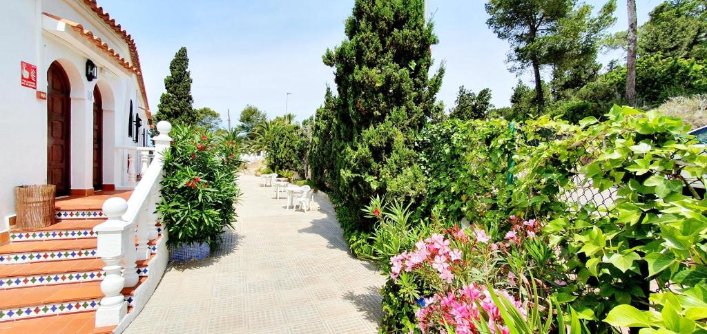 a garden with flowers and a white fence at Granada Apartments Familiar Deluxe in Portinatx