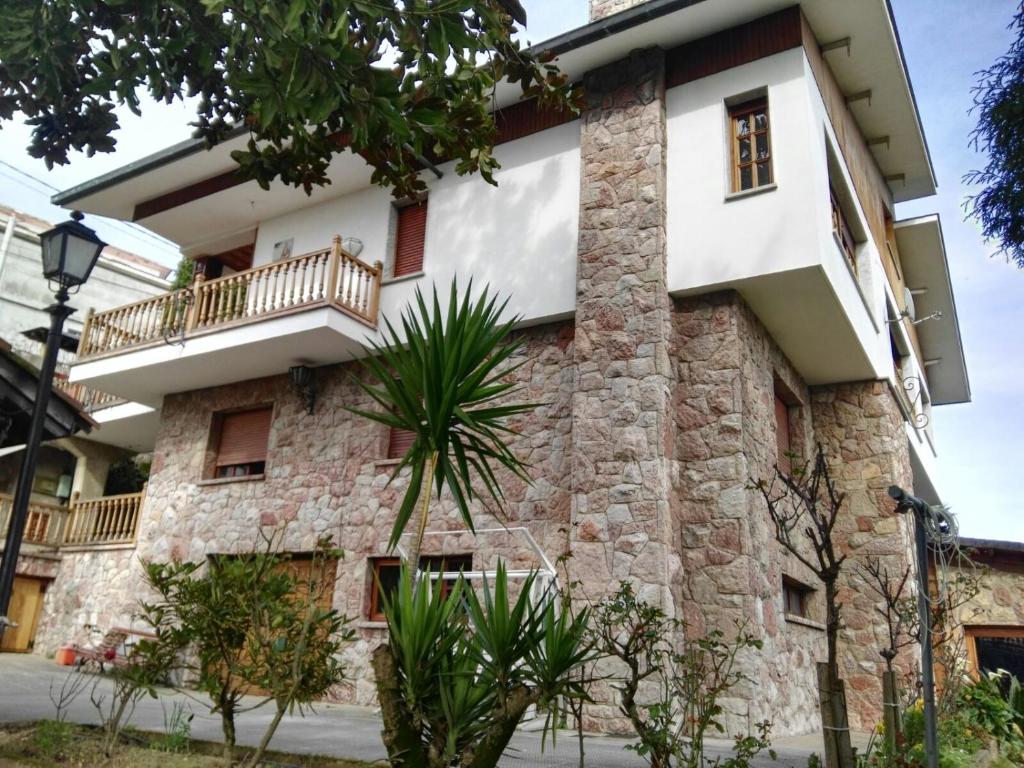 ein Steingebäude mit Balkon in der Unterkunft Albergue La Costana in Oviedo