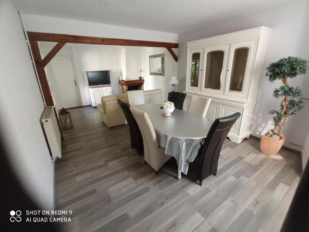 a dining room and living room with a table and chairs at La Providence in Chaumont
