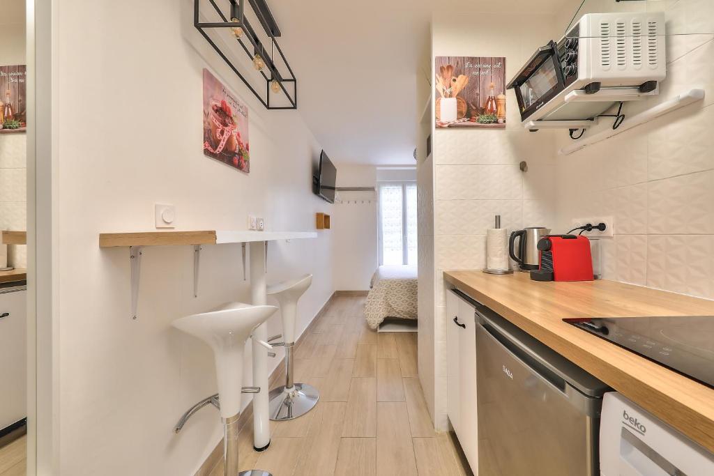 a kitchen with white walls and a wooden counter top at Studio Le Rosier - Paris Gare du Nord en 15 min - in Deuil-la-Barre