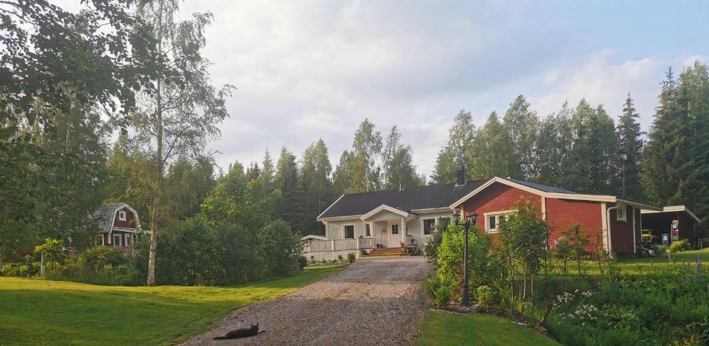 a house with a driveway in front of a yard at Hyttingsfabodstugor in Borlänge