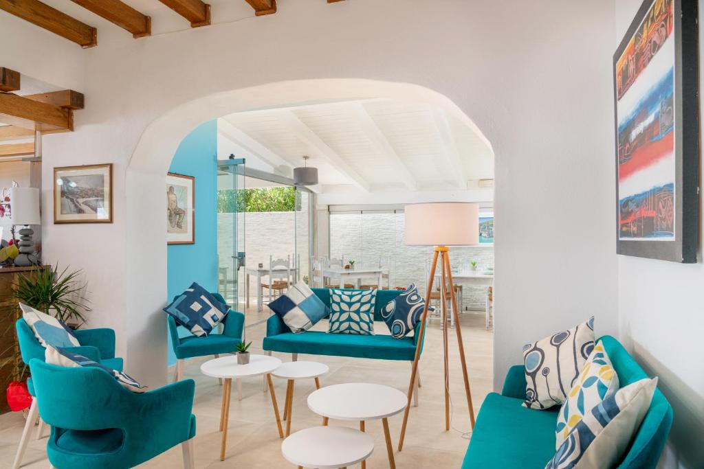 a living room with blue chairs and a couch at Hotel Ristorante La Conchiglia in Cala Gonone