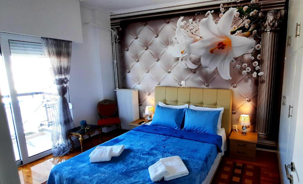 a bedroom with a blue bed with a flower on the wall at LUXURY APARTMENT Port of Piraeus in Piraeus