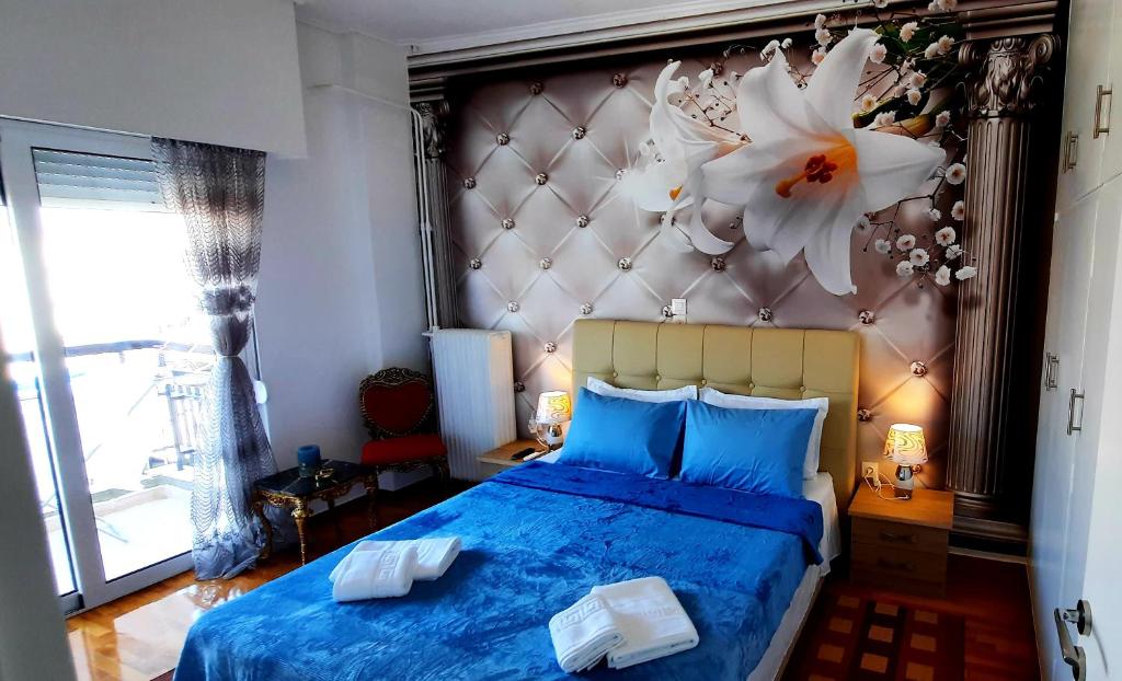 Un dormitorio con una cama azul con una flor en la pared en LUXURY APARTMENT 6 PEOPLE PORT OF PIRAEUS, en Pireo