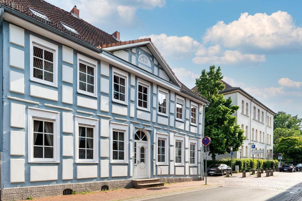 Apartment & Junior-Suite Schloßstraße am Park في بورغدورف: مبنى ازرق وابيض على جانب شارع