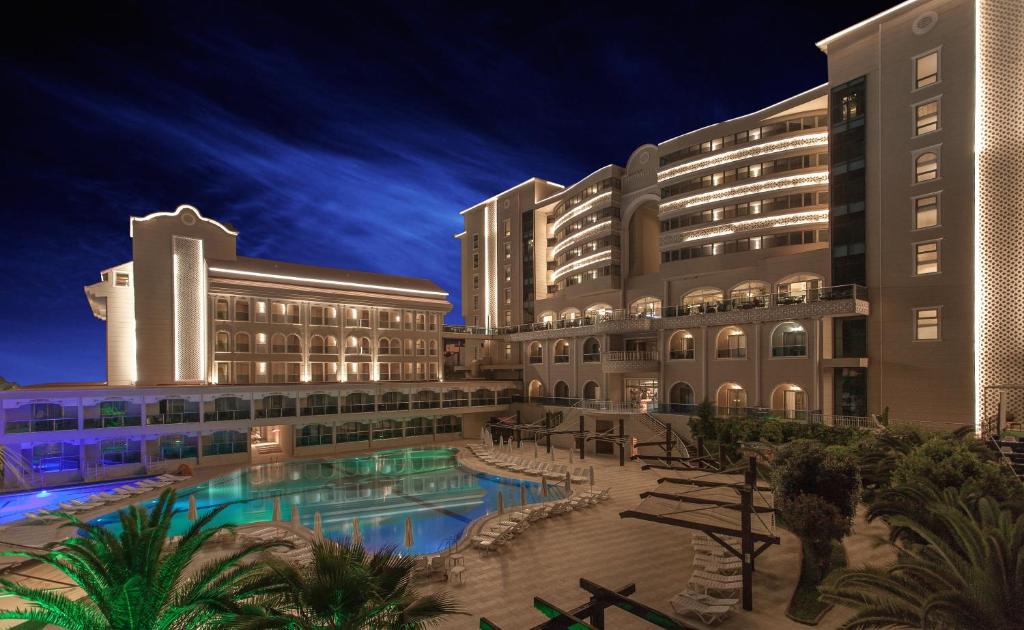 a resort with a swimming pool in front of two buildings at Hotel Sultan Of Side in Side