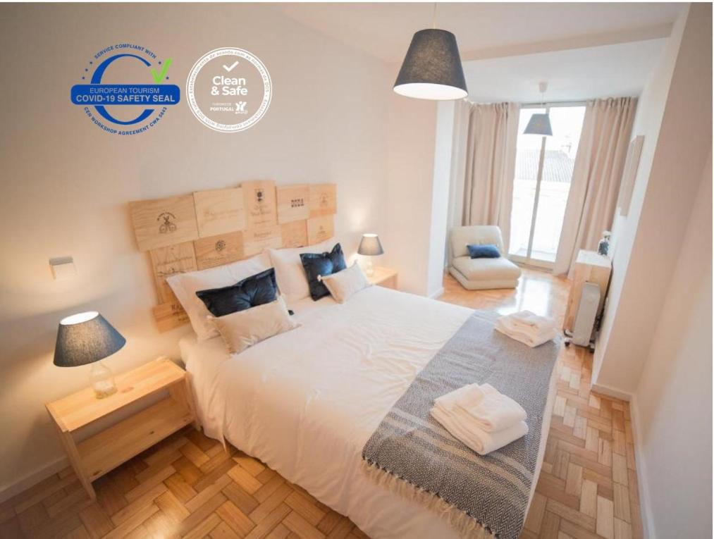 Un dormitorio con una gran cama blanca y una lámpara en OPORTO GUEST Wine Experience Flat, en Oporto