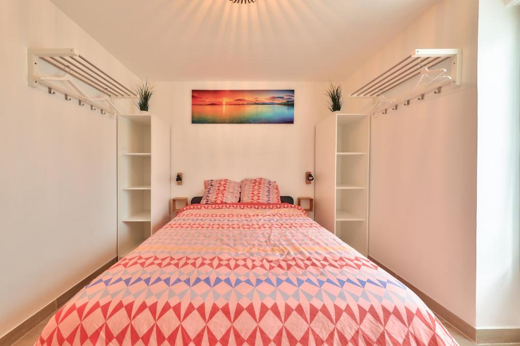 - une chambre avec un lit doté d'un couvre-lit coloré dans l'établissement L'Olivier - Paris Gare du Nord en 15 min -, à Deuil-la-Barre