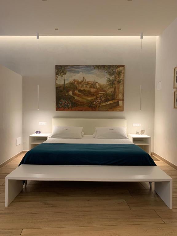 Atto Primo Studio Apartment في فيرونا: غرفة نوم بسرير كبير عليها لوحة على الحائط