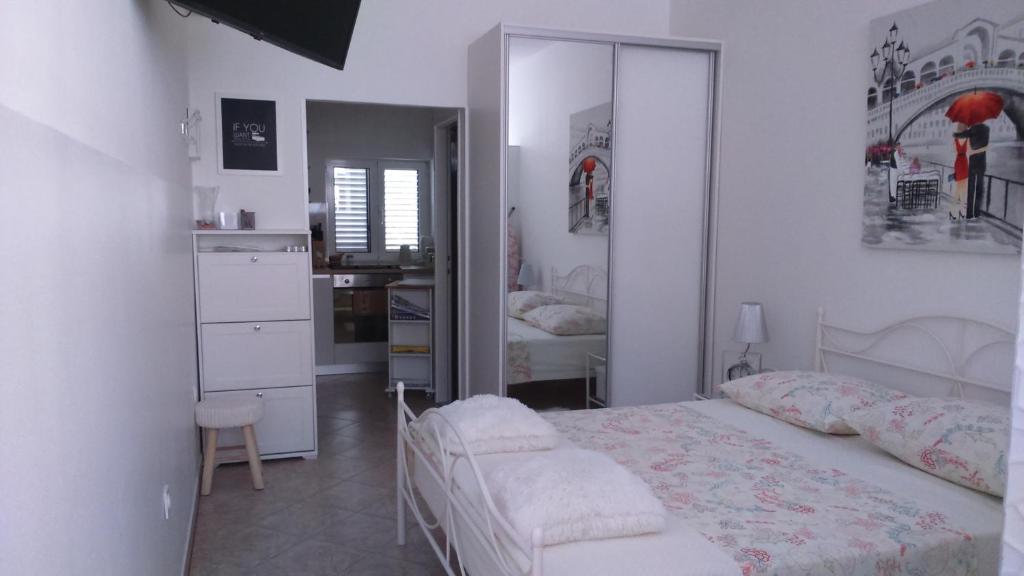 ein weißes Schlafzimmer mit einem Bett und einem Spiegel in der Unterkunft Swiss holiday 4 in Split