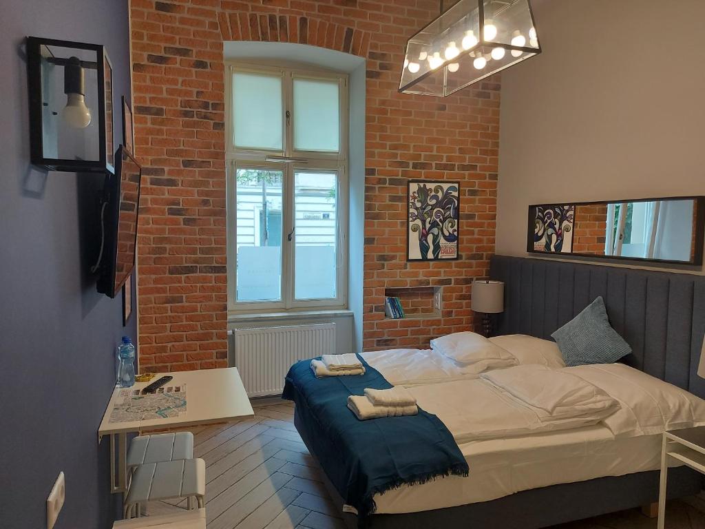 um quarto com uma cama e uma parede de tijolos em JUWEL Uroczy Apartament 2B Stare Miasto Kraków em Cracóvia