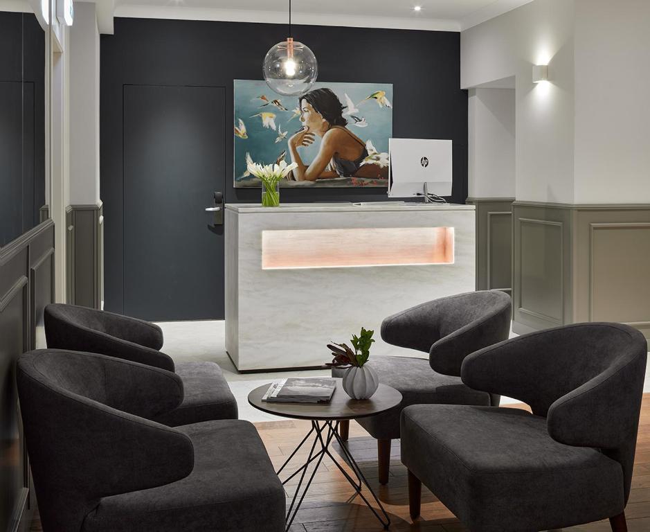 une salle d'attente avec des chaises, une table et un tableau dans l'établissement B60 Hotel, à Moscou