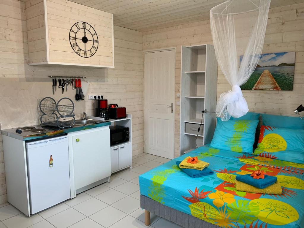 una cocina y un dormitorio con una cama en una habitación en Les Lianes De Mysore, en Deshaies