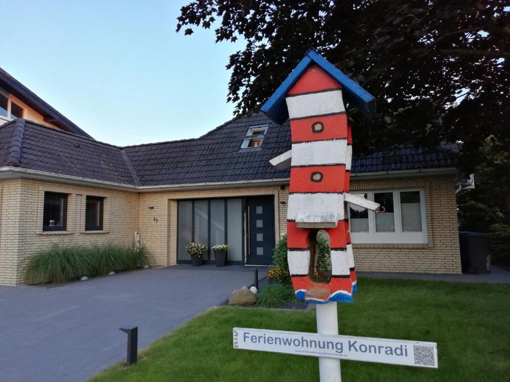 une maison avec un panneau devant une cour dans l'établissement Ferienwohnung Hermann-Daur-Weg, à Cuxhaven