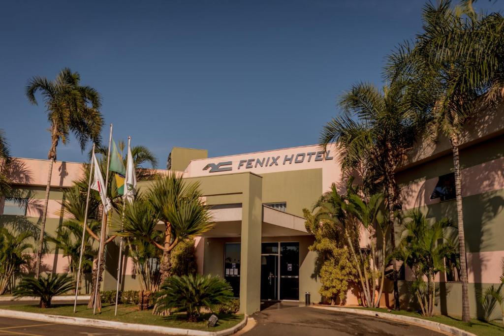 afw hotel with palm trees in front of it at Fenix Hotel Araxá in Araxá