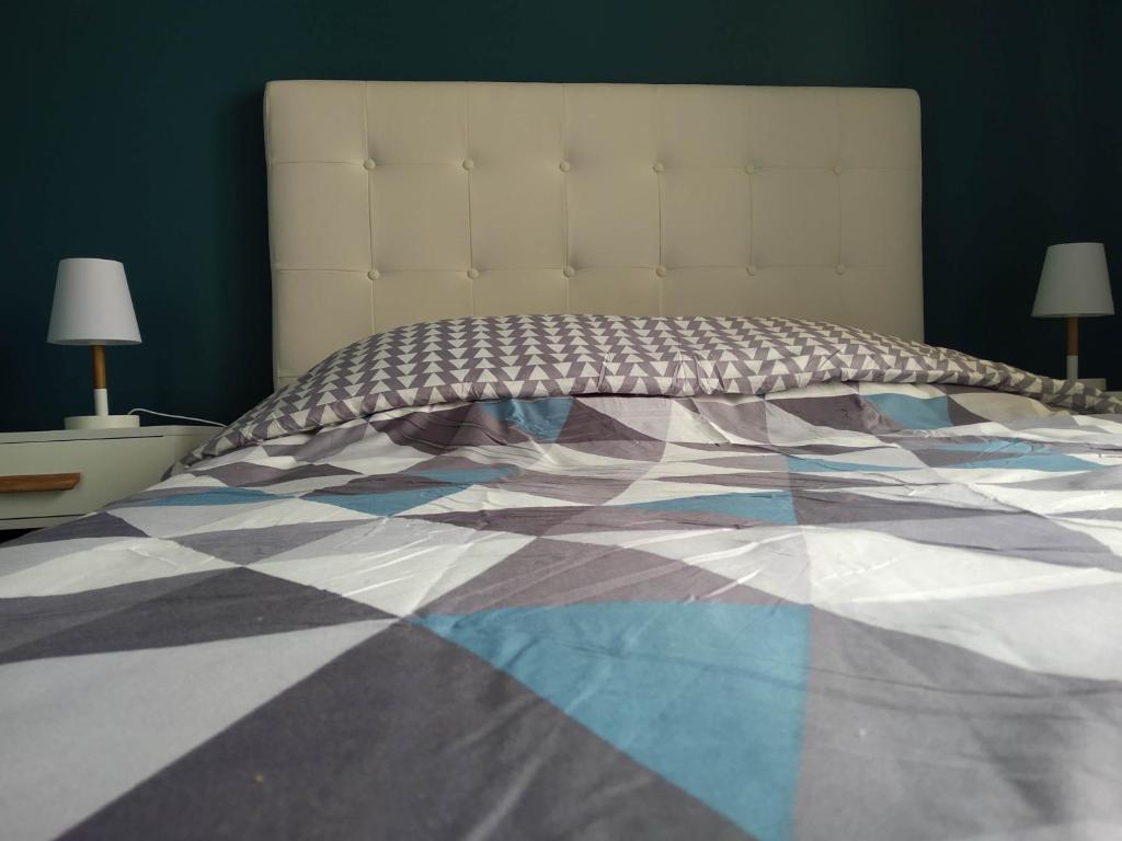 a bed with a quilt on it in a bedroom at Le Central Vittel 206 in Vittel